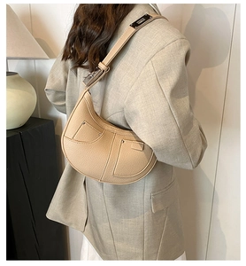Detail of beige crescent shoulder bag in pebble leather with silver metal buckle