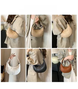Detail view of crescent shoulder bags in multiple colors with T-shaped stitching accents