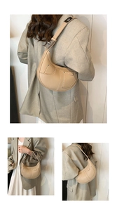 Detail view of crescent shoulder bag featuring lychee texture and silver metal buckle