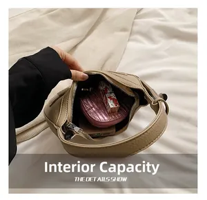 Internal capacity of beige crescent bag showing lipstick and phone inside the compartment