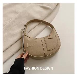 Detailed view of beige hobo bag with pebble leather texture and silver rivet hardware