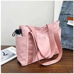 Pink large capacity canvas tote bag with multi-pocket design on wooden table