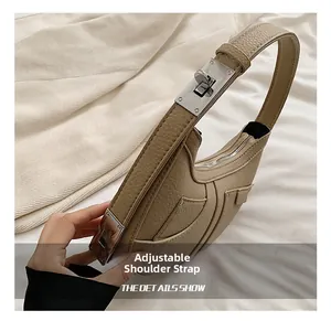 Detail of adjustable shoulder strap with silver buckle on khaki crescent leather bag