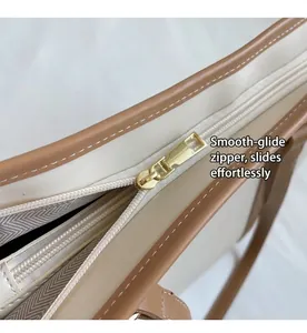 Detailed macro view of the gold metal zipper and stitching on the tote bag's top