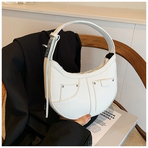 Detail of white pebbled leather crescent bag with silver rivets and wide handle