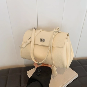 Minimalist beige underarm bag with lychee texture and silver twist lock in lifestyle setting
