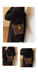 Detail of vintage brown suede bucket bag with gold metal clasp and stitching details