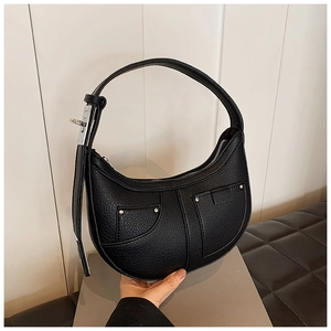 Detail of black crescent hobo bag in lychee leather with silver hardware studs