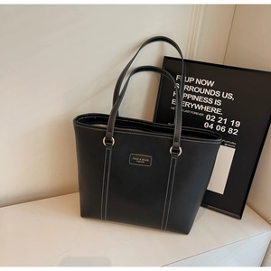 Detail shot of black tote bag showing white contrast stitching and ZSKE brand label
