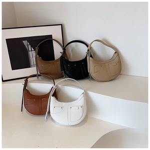 Collection of crescent underarm bags in five colors on minimalist display stands