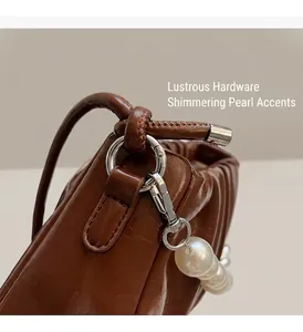 Detailed macro view of the brown ruched leather bag with premium silver hardware and pearls