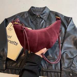 Burgundy suede croissant bag with pleated details and adjustable shoulder strap for women