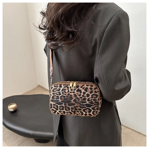 Detailed back view of a double-zipper leopard print crossbody bag worn with a brown blazer