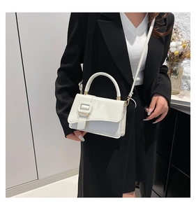 Modern white minimalist handbag with leather texture and square buckle shown on a model