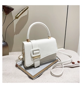 Detailed macro view of a white PU leather handbag featuring a stylish gold metal buckle