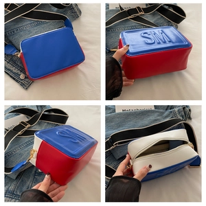 Détails du sac bandoulière tricolore avec logo SM embossé et large sangle rayée ajustable