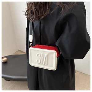 Détail du sac bandoulière en cuir tricolore avec logo SM et large bandoulière