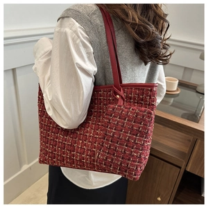 Gros plan sur un sac cabas en tweed rouge avec tissage doré et bandoulière en cuir
