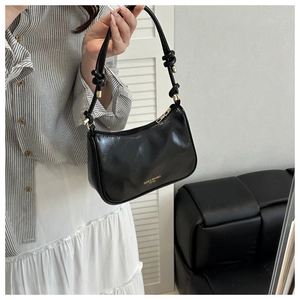 Vue détaillée du sac porté épaule noir avec bandoulière nouée et détails dorés chic