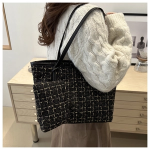 Détail du cabas en tweed et de sa pochette assortie montrant le tissage noir et doré