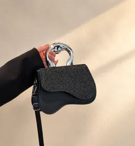 Detailansicht einer schwarzen Satteltasche mit Pailletten und Metallgriff in Silber
