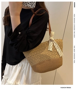 Close-up of hollow weave straw tote bag with brown leather handles and lace bow detail