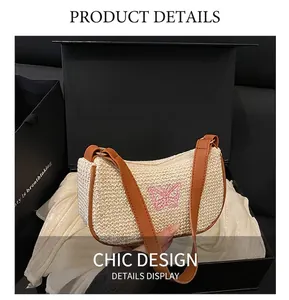 Dettaglio borsa a spalla in paglia color crema con ricamo a farfalla rosa