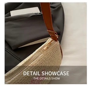 Dettaglio della cerniera dorata e del ricamo rosa sulla borsa intrecciata beige