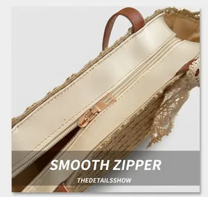 Detail of a smooth light gold zipper closure on an ivory woven summer beach bag