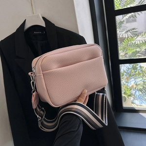 Borsa fotografica in pelle rosa con una tracolla larga in tessuto a righe alla moda