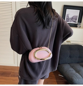 Detail view of pink mini box bag with gold metal buckle on oversized waffle suit