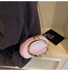 Detail of pink leather clutch with large gold C buckle and dual metal zippers