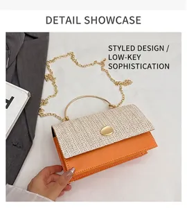 Detail of woven straw and orange leather handbag with gold metal handle and chain strap