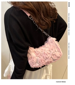 Détail des fleurs en mesh 3D sur un sac à bandoulière rose avec bandoulière en chaîne