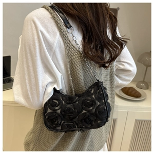 Detail der schwarzen Netztasche mit 3D-Blütenblättern und silbernem Kettenriemen