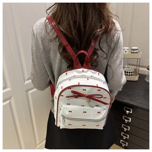 Close-up of red bow polka dot backpack with white mesh fabric and heart charm