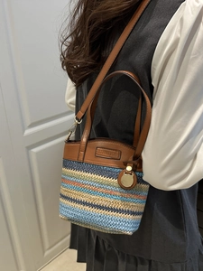 Colorful woven striped tote bag with brown leather straps and metal pendant detail