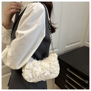 Detail of white 3D floral fabric roses on women shoulder bag with silver chain strap