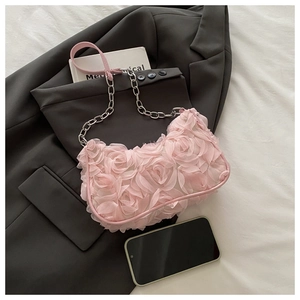 Détail d'un sac à bandoulière rose avec fleurs de rose en maille 3D et chaîne métallique