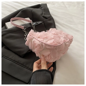 Détail d'un sac rose avec des pétales de fleurs en mesh 3D et chaîne argentée