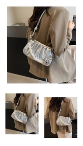 Silver pleated cloud bag featuring pearl handle and metallic heart chain detail