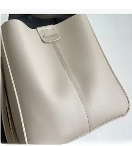 Close-up of the textured beige PU leather material and vertical stitching on the bucket bag