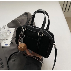 Détail du sac bowling en toile noire avec charms de sport et bandoulière amovible