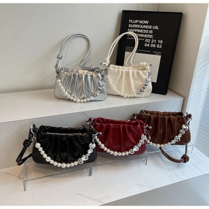 Detailed view of ruched cloud bags in five colors with pearl heart accent straps