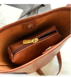 Interior view of brown leather tote showing inner zipper pouch and magnetic closure