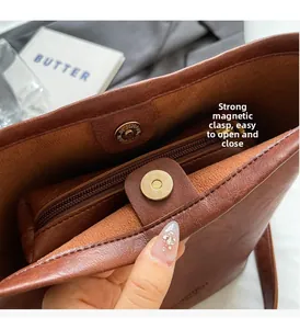 Detail of brown leather bag featuring a secure magnetic closure and internal zipper pocket