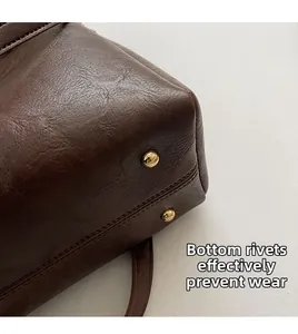 Detail view of golden bottom rivets on brown leather bucket bag for wear protection