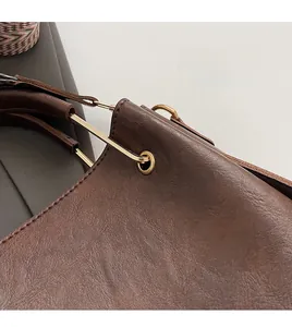 Close-up of brown litchi pattern leather texture and golden hardware buckle detail