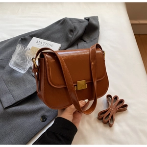 Detailed view of a vintage brown square bag with oil-wax texture and metal buckle