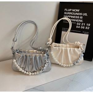 Detail of ruched cloud bags in silver and cream with pearl heart charms and knot straps